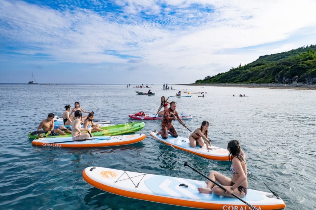旅客在小琉球海邊體驗 SUP 與水上活動，準備展開海島行程